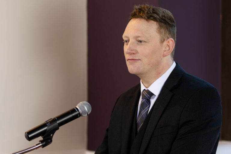 An officiant making a speech at a podium
