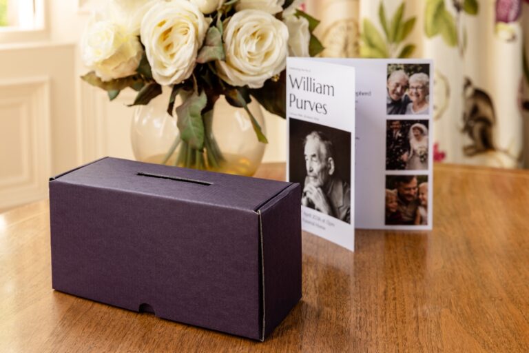 A charity box and funeral programme